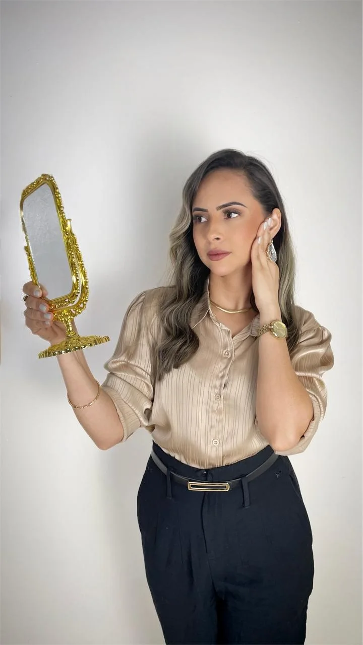 Suellen Bandeira segurando um espelho dourado